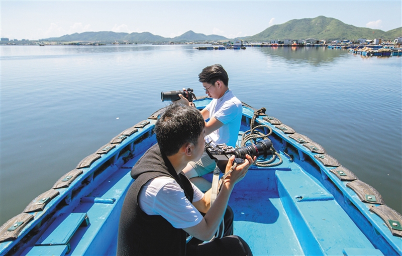参加南湾猴岛生态科学影像研学营的学生，在新村港拍摄疍家水上生活素材。本报记者 武威 摄.jpg